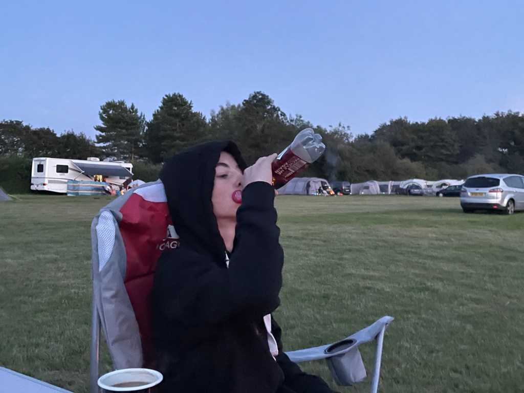 C wearing a hoody and enjoying a soda