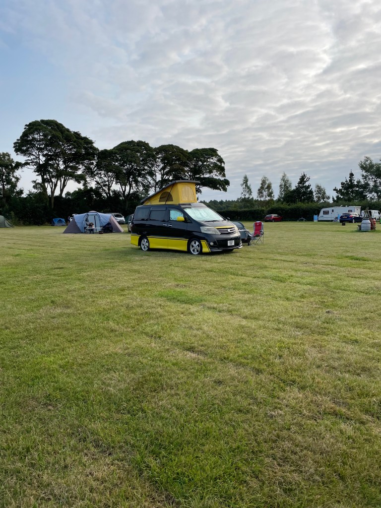 Black and yellow Toyota Alphard camper van at Breck Farm Camp site in Norfolk