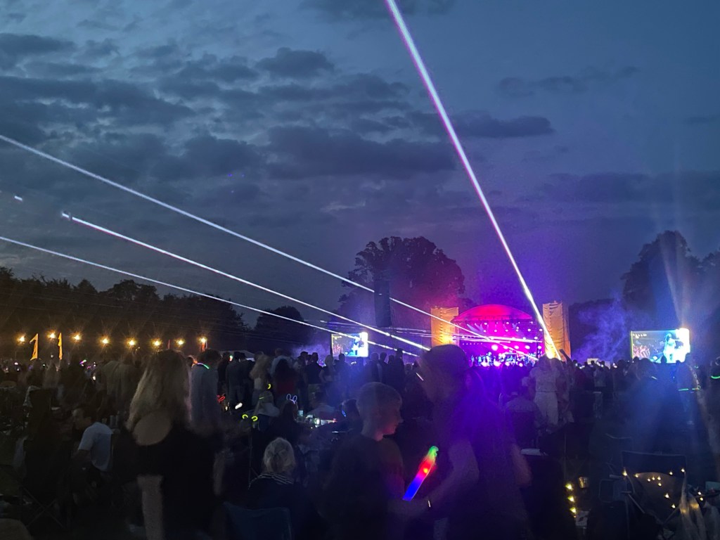 Outdoor stage after dark with impressive laser show over the heads of the crowds